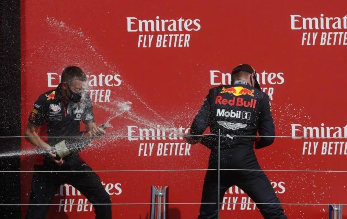 Winner Red Bull's Dutch driver Max Verstappen (R) celebrates on the podium with Will Courtenay, Red Bull Racing Head of Race Strategy (L) after the F1 70th Anniversary Grand Prix at Silverstone on August 9, 2020 in Northampton. The race commemorates the 70th anniversary of the inaugural world championship race, held at Silverstone in 1950. Frank Augstein / POOL / AFP