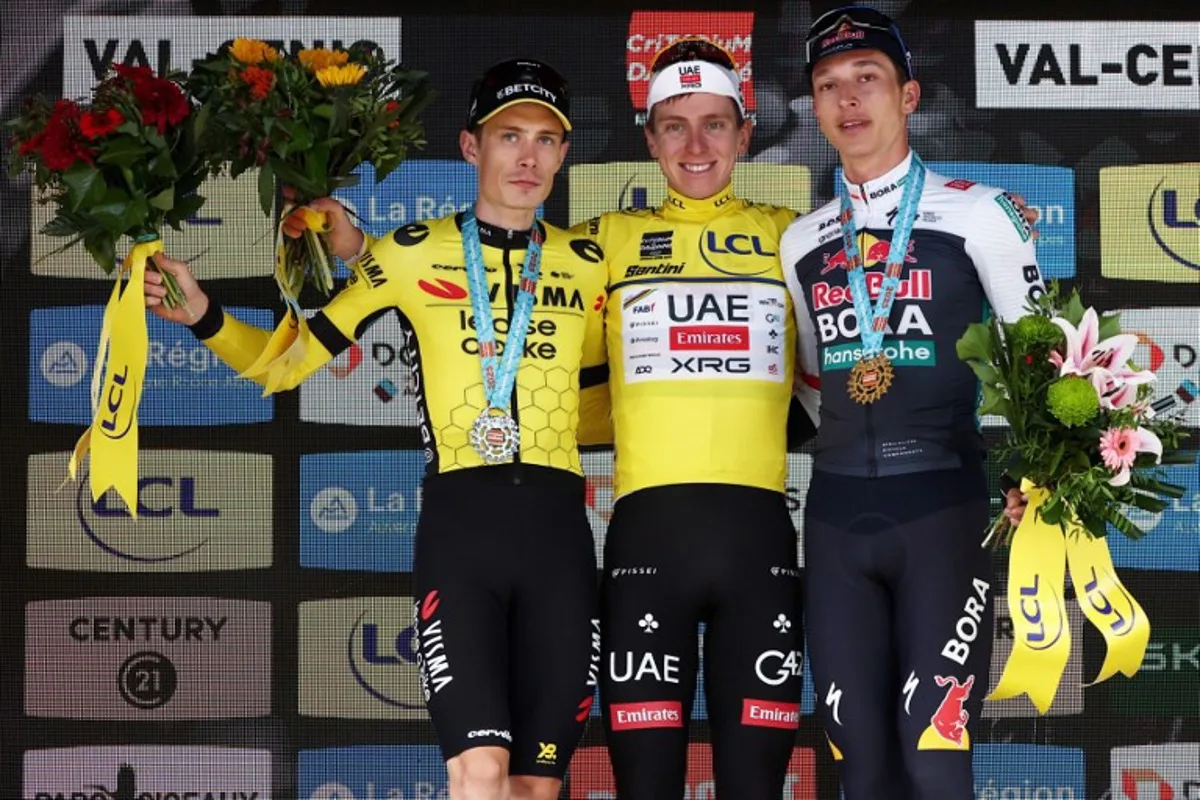 Second placed for the overall race Team Visma - Lease a Bike's Danish rider Jonas Vingegaard, first placed UAE Team Emirates XRG's Slovenian rider Tadej Pogačar wearing the overall leader's yellow jersey and third placed Red Bull - BORA - hansgrohe's German rider Florian Lipowitz celebrate on the podium of the 8th and final stage of the 77th edition of the Criterium du Dauphine cycling race, 133,3 km between Val-d'Arc and Val-Cenis - Plateau du Mont Cenis, on June 15, 2025. Anne-Christine POUJOULAT / AFP
