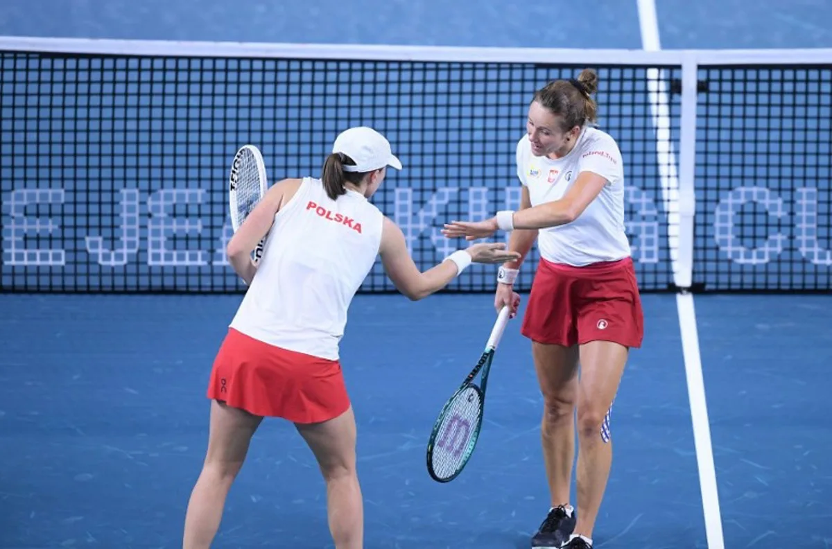 Poland's Katarzyna Kawa and Iga Swiatek celebrate a point during their quarter-finals double tennis match between Poland and Czech Republic at the Billie Jean King Cup Finals at the Palacio de Deportes Jose Maria Martin Carpena in Malaga, Spain, on November 16, 2024.   JORGE GUERRERO / AFP