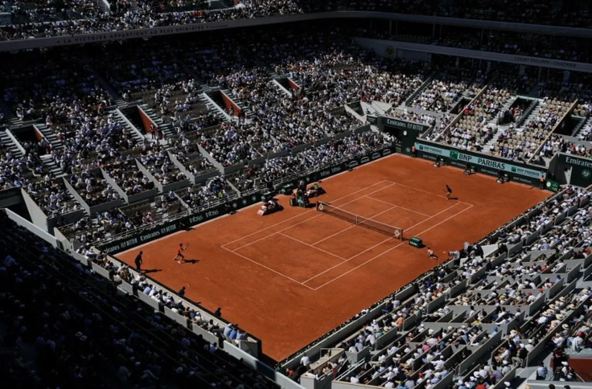 Spectators watch Italy's Jannik Sinner and Spain's Carlos Alcaraz play their men's singles semi final match on Court Philippe-Chatrier on day thirteen of the French Open tennis tournament at the Roland Garros Complex in Paris on June 7, 2024. Dimitar DILKOFF / AFP