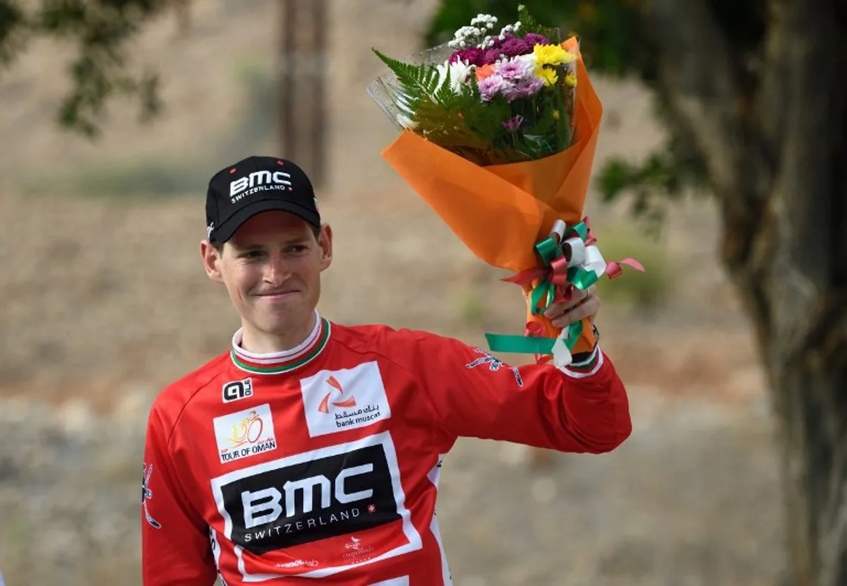 Belgium's Ben Hermans, leader of the BMC Racing Team, waves a bouquet on the podium during the victory ceremony of the 3rd stage of the cycling Tour of Oman between Sultan Qaboos University and Quriyat on February 16, 2017, in Quriyat.  Eric Feferberg / AFP