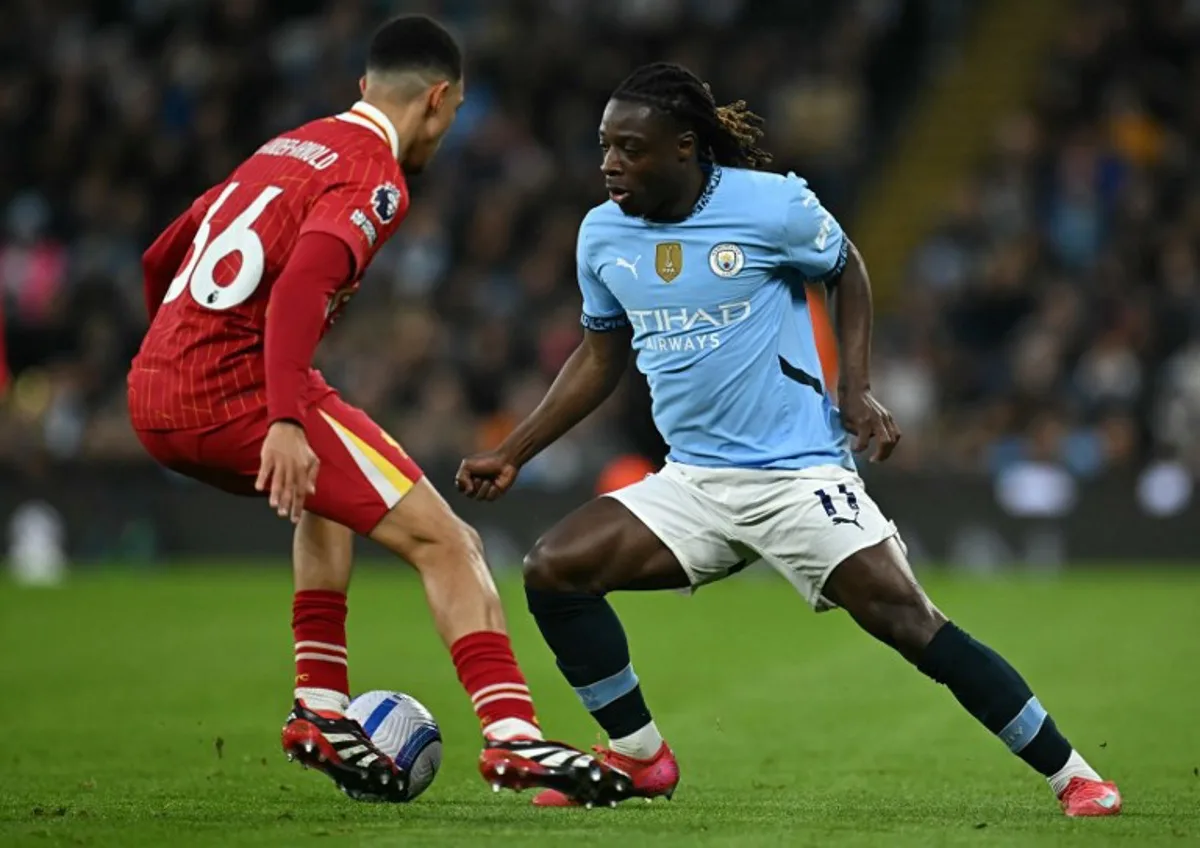 Liverpool's English defender #66 Trent Alexander-Arnold (L) vies with Manchester City's Belgian midfielder #11 Jeremy Doku during the English Premier League football match between Manchester City and Liverpool at the Etihad Stadium in Manchester, north west England, on February 23, 2025.  Paul ELLIS / AFP