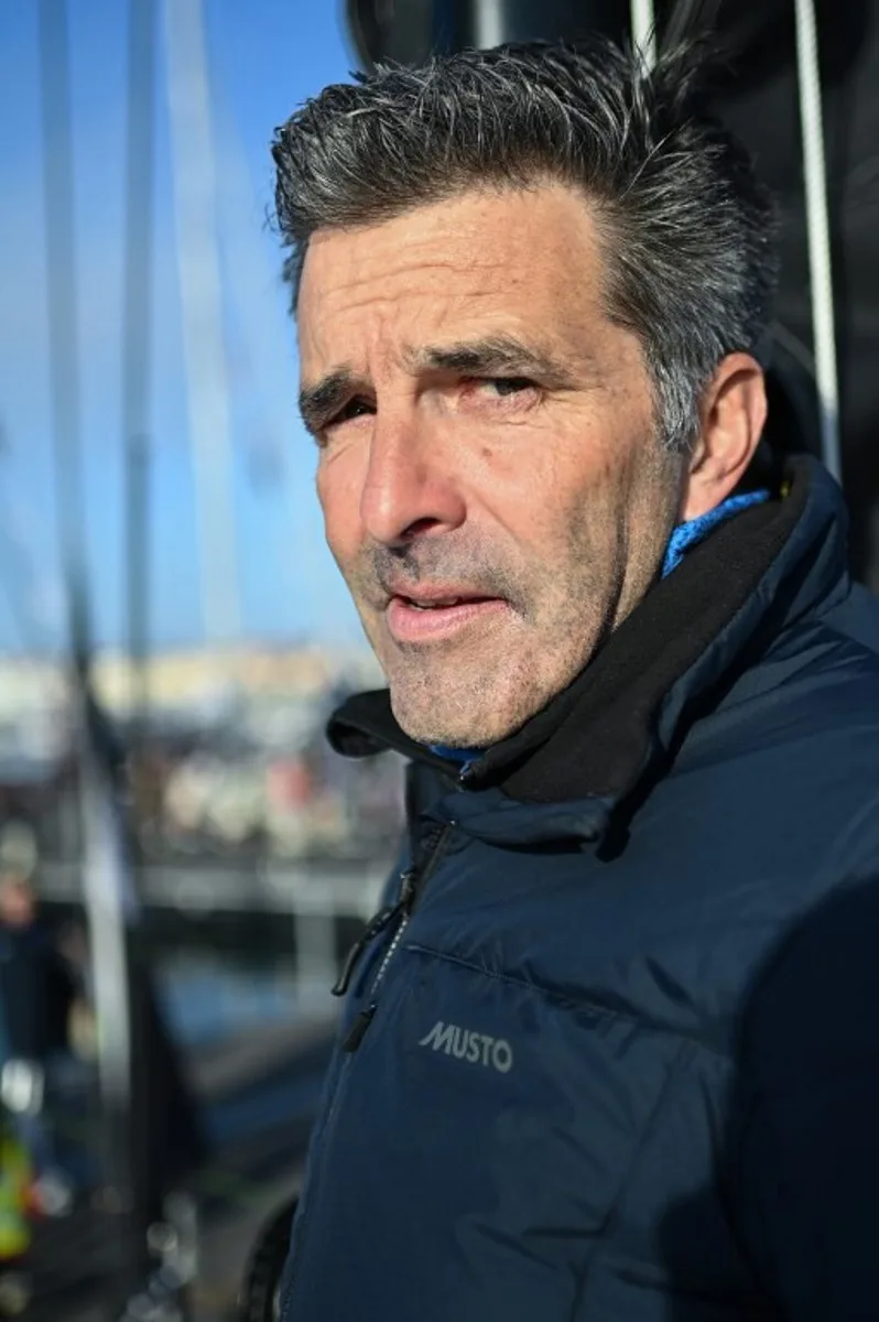 Belgian skipper Denis Van Weynbergh poses aboard his Imoca monohull "D'ieteren Group" ahead of the 10th edition of the Vendee Globe around the world monohull solo sailing race, at the Vendee Globe village in Les Sables-d'Olonne, western France on November 5, 2024.   Sebastien Salom-Gomis / AFP