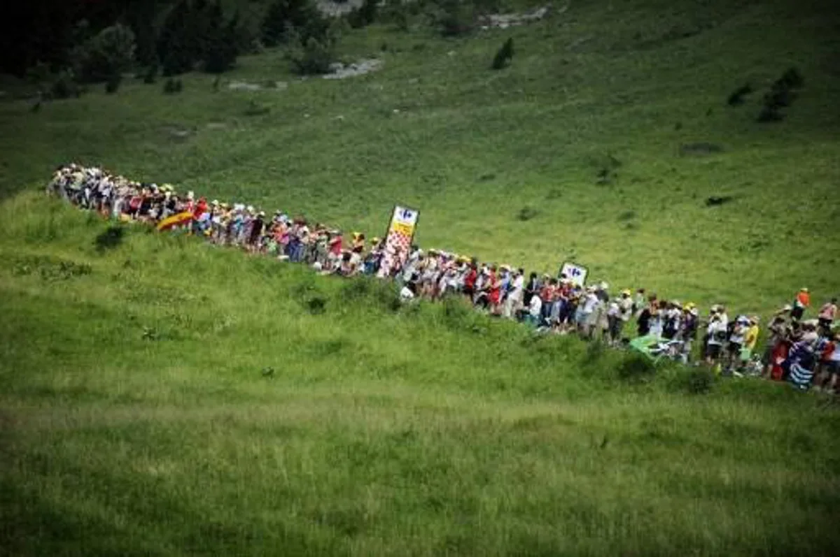 Fans wait for riders in the Col des Saisies pass during the 204,5 km and 9th stage of the 201 Tour de France cycling race run between Morzine Avoriaz ski resort and Saint-Jean de Maurienne, in Savoy, on July 13, 2010. AFP PHOTO / LIONEL BONAVENTURE