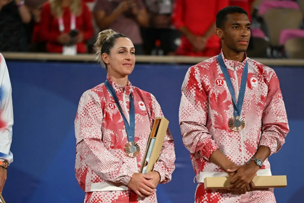 Bronze medallists Canada's Gabriela Dabrowski and Canada's Felix Auger-Aliassime pose with their medals on the podium at the presentation ceremony for the mixed doubles tennis event on Court Philippe-Chatrier at the Roland-Garros Stadium during the Paris 2024 Olympic Games, in Paris on August 2, 2024.   CARL DE SOUZA / AFP