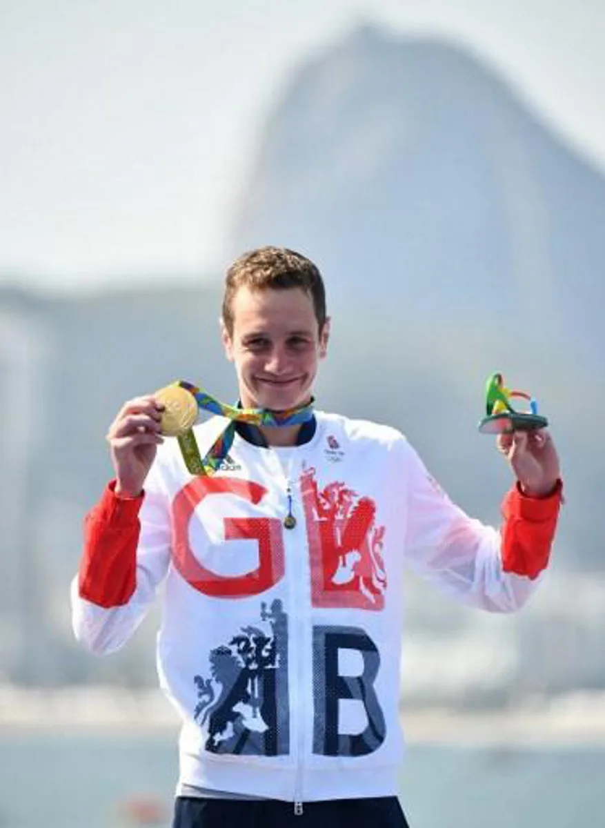 Britain's Alistair Brownlee poses with his gold medal after the men's triathlon at Fort Copacabana during the Rio 2016 Olympic Games in Rio de Janeiro on August 18, 2016. 
Leon NEAL / AFP