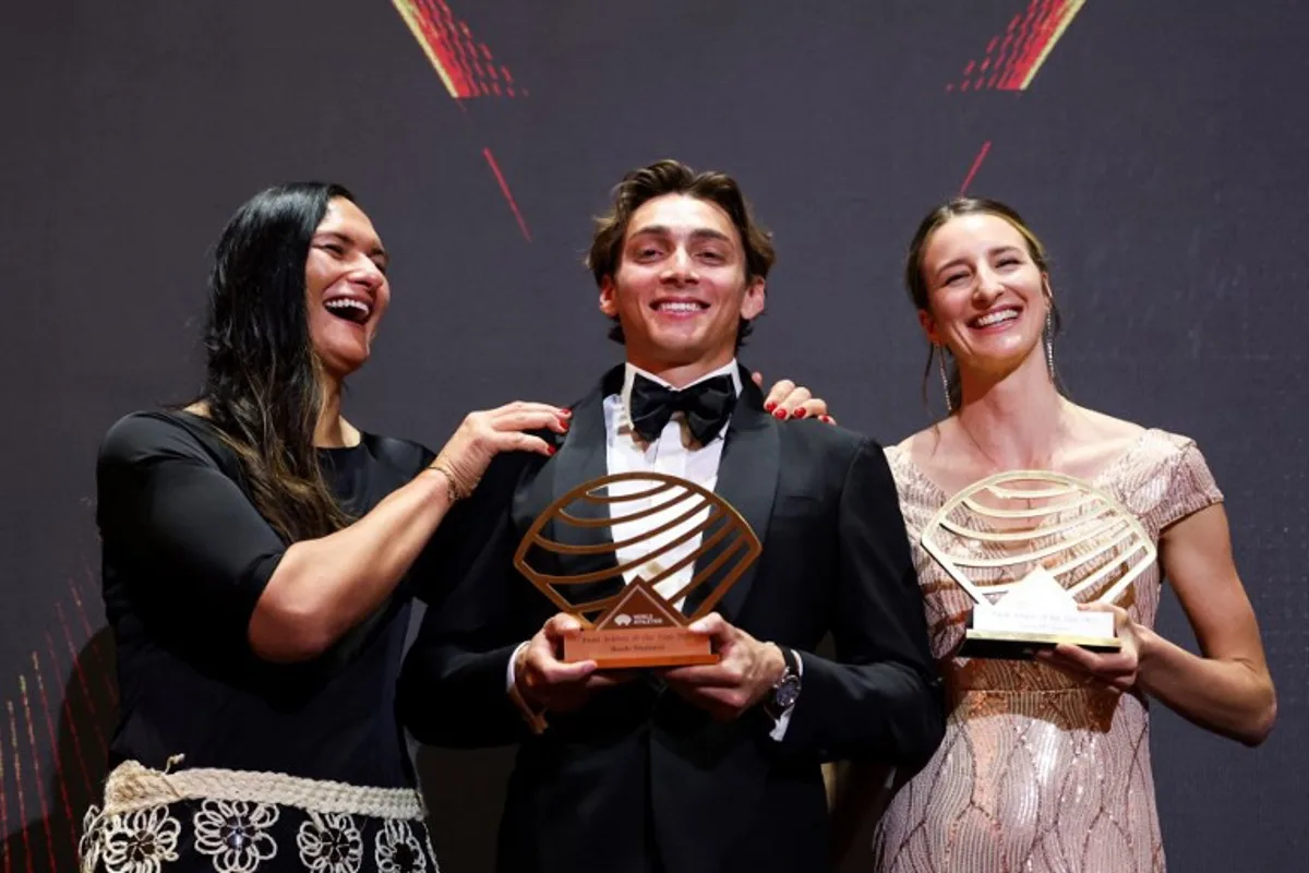 Sweden's world pole vault champion Armand Duplantis (C) holds his Men's field athlete of the year award and Australia's world high jump champion Nicola Olyslagers (R) holds her Women's field athlete of the year award as they pose on stage during the World Athletics Awards 2025 in Monaco, on November 30, 2025. Valery HACHE / AFP