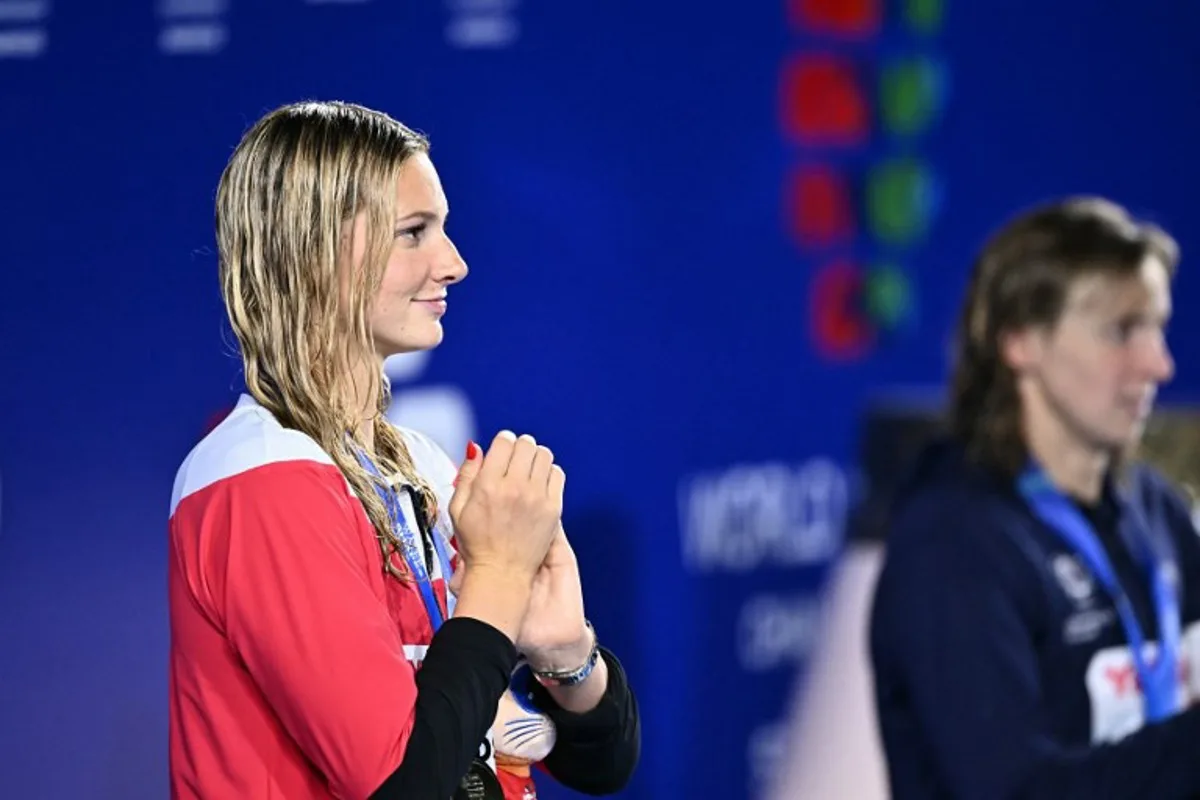 Gold medallist Canada's swimmer Summer Mcintosh celebrates on the podium of the women's 400m freestyle swimming event during the 2025 World Aquatics Championships in Singapore on July 27, 2025. MANAN VATSYAYANA / AFP