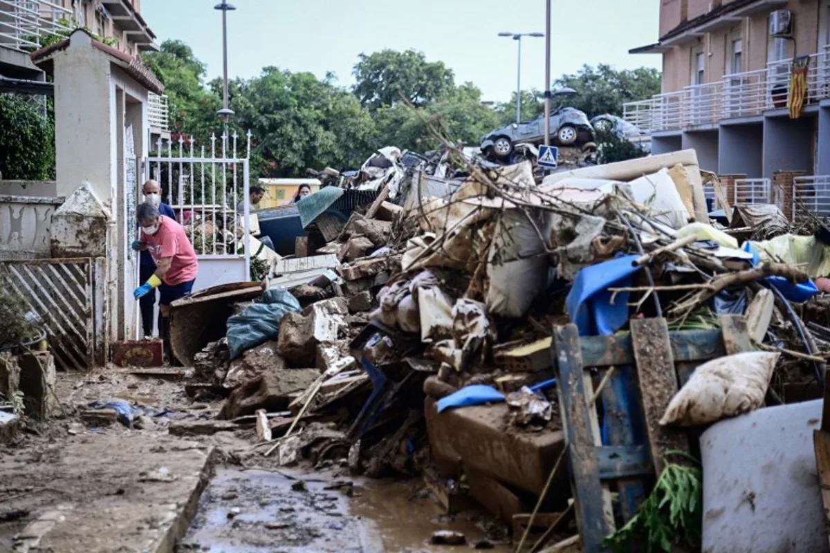 People continue clean up work follwing devastating floods in Alfafar, in the region of Valencia, eastern Spain, on November 4, 2024. The death toll from Spain's worst floods in a generation has climbed to 217, according to resuers. JOSE JORDAN / AFP