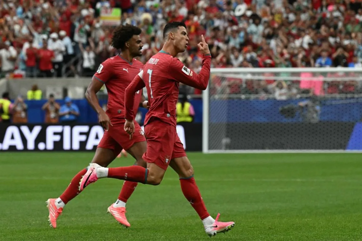 Portugal's forward #07 Cristiano Ronaldo (R) celebrates after scoring the opening goal during the 2026 World Cup Group K football match between Portugal and Uzbekistan at the Houston Stadium in Houston on June 23, 2026. RONALDO SCHEMIDT / AFP