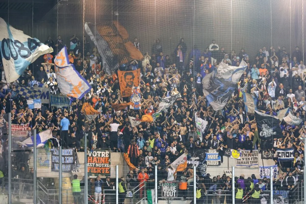 Marseille's supporters cheer their team on from the stands during the French L1 football match between RC Strasbourg and Marseille (OM) at the Stade de la Meinau in Strasbourg, on September 29, 2024.  Abdesslam MIRDASS / AFP