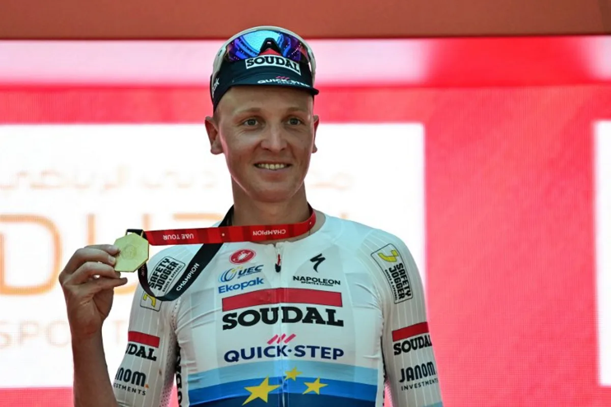 Team Soudal Quick-Step Belgian rider Tim Merlier celebrates on the podium after winning the fifth stage of the UAE Tour cycling race between the American University and the Hamdan bin Mohammed Smart University in Dubai on February 21, 2025.  Giuseppe CACACE / AFP