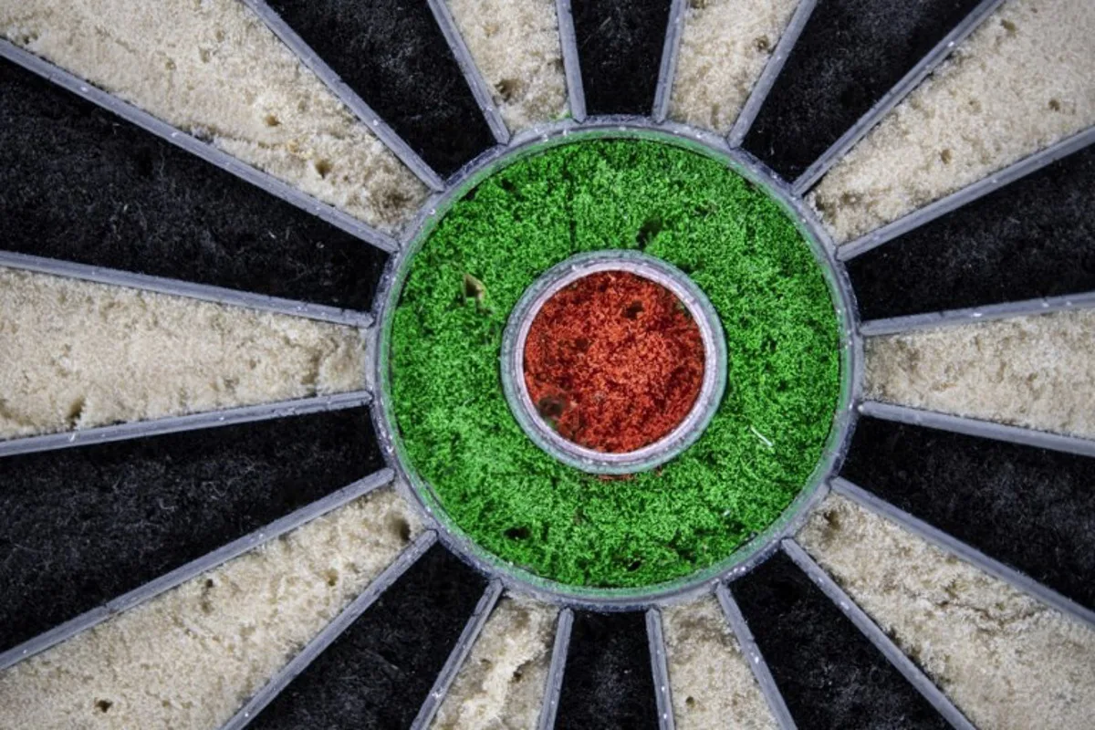 This photograph taken June 7, 2022 shows a close-up of the center of a darts target in Malguenac, north-western France. In the bar of a small town in central Brittany, Thibault Tricole trains with a confident gesture: the first Frenchman to make a name for himself on the semi-pro darts circuit, is now aiming for the extravagances of the pro circuit. FRED TANNEAU / AFP