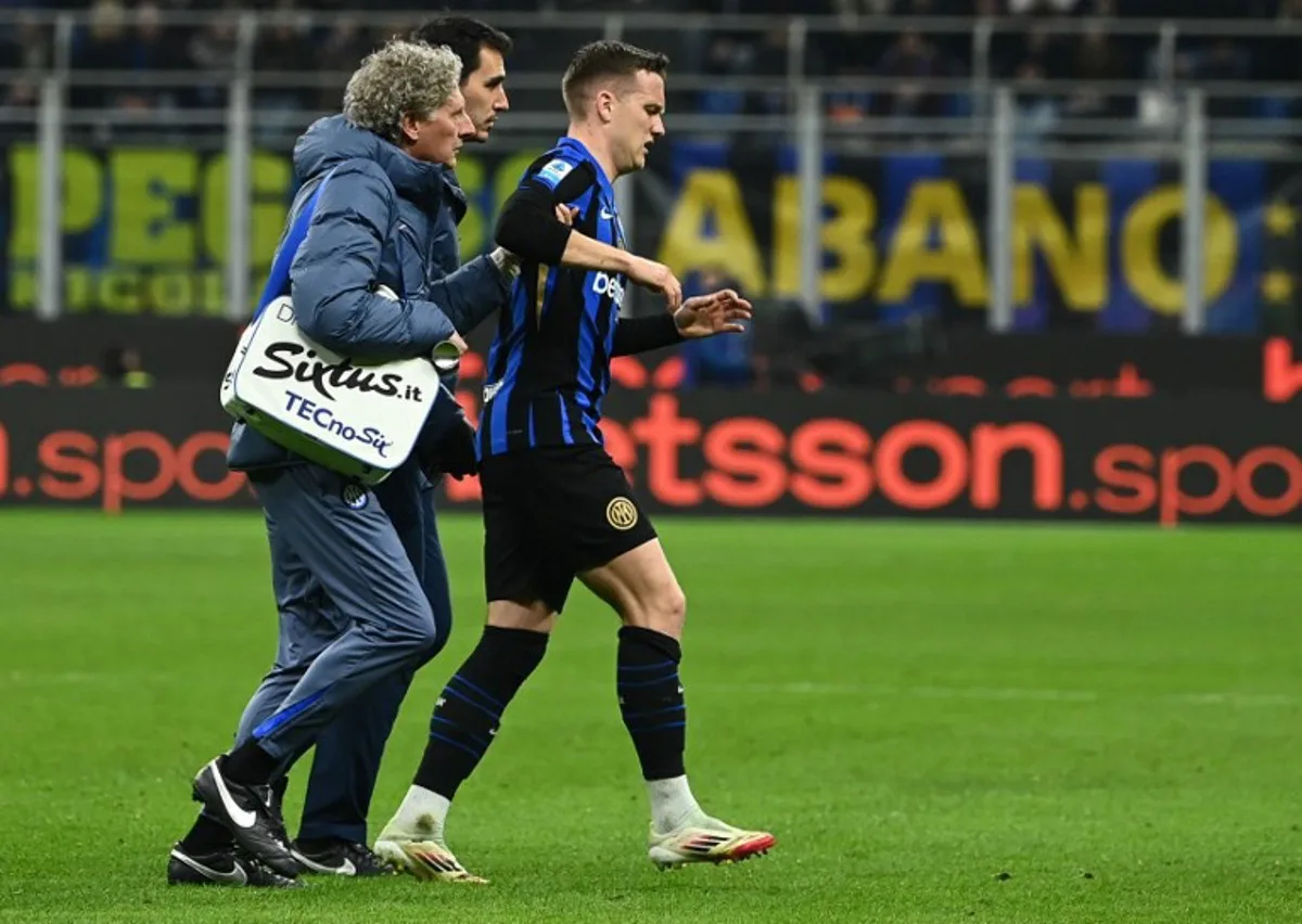 Inter Milan's Polish midfielder #07 Piotr Zielinski (R) is helped as he leaves the field injured during the Italian Serie A football match between Inter Milan and Monza at the San Siro stadium in Milan, on March 8, 2025.  Isabella BONOTTO / AFP