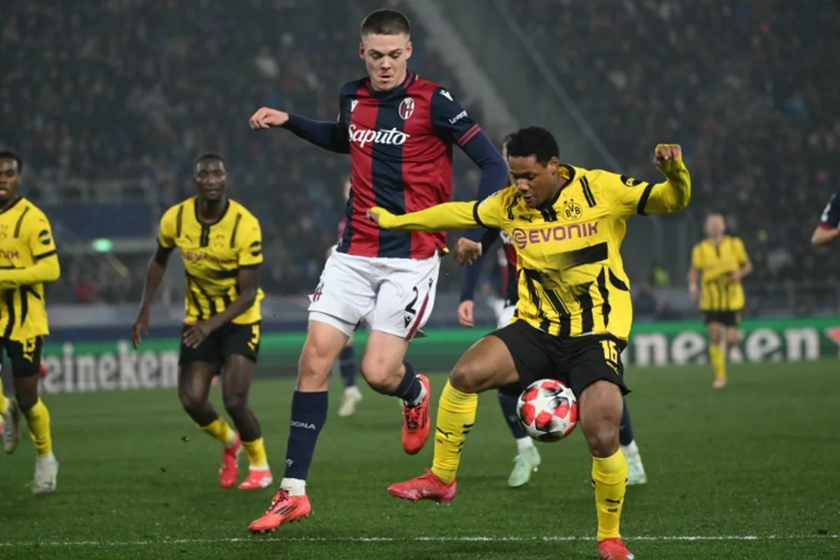 Dortmund's Belgian forward #16 Julien Duranville (R) fights for the ball with Bologna's Swedish midfielder #02 Emil Holm during the UEFA Champions League football match between Bologna and Borussia Dortmund at the Renato Dall'Ara stadium in Bologna on January 21, 2025.  Alberto PIZZOLI / AFP