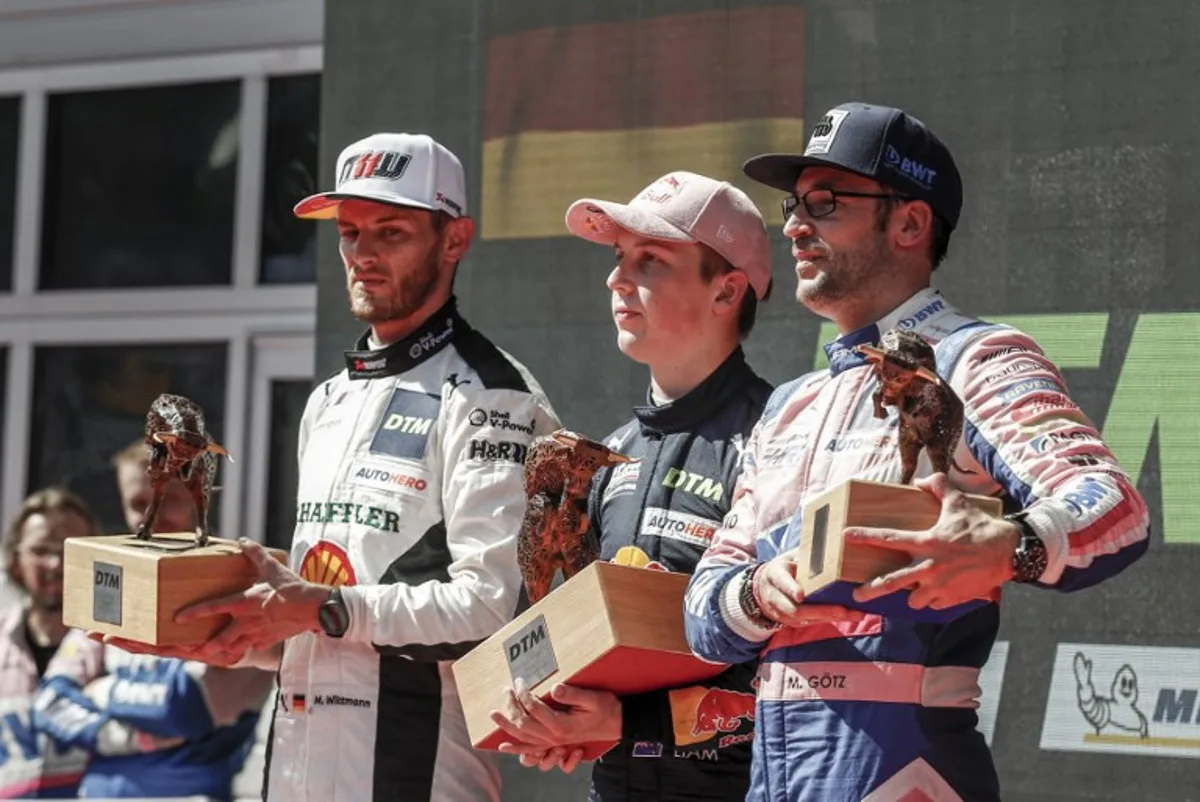 Second placed Germany's Marco Wittmann of the Walkenhors Motorsport Team (L), first placed New Zealand's Liam Lawson of the Red Bull Alphatauri AF Corse Team and third placed Germany's Maximilian Goetz of the Haupt Racing Team Team stand on the podium during the winners' ceremony after the end of the second race of the DTM of Austria, on September 5, 2021 at the Red Bull Ring in Spielberg, Austria. ERWIN SCHERIAU / APA / AFP