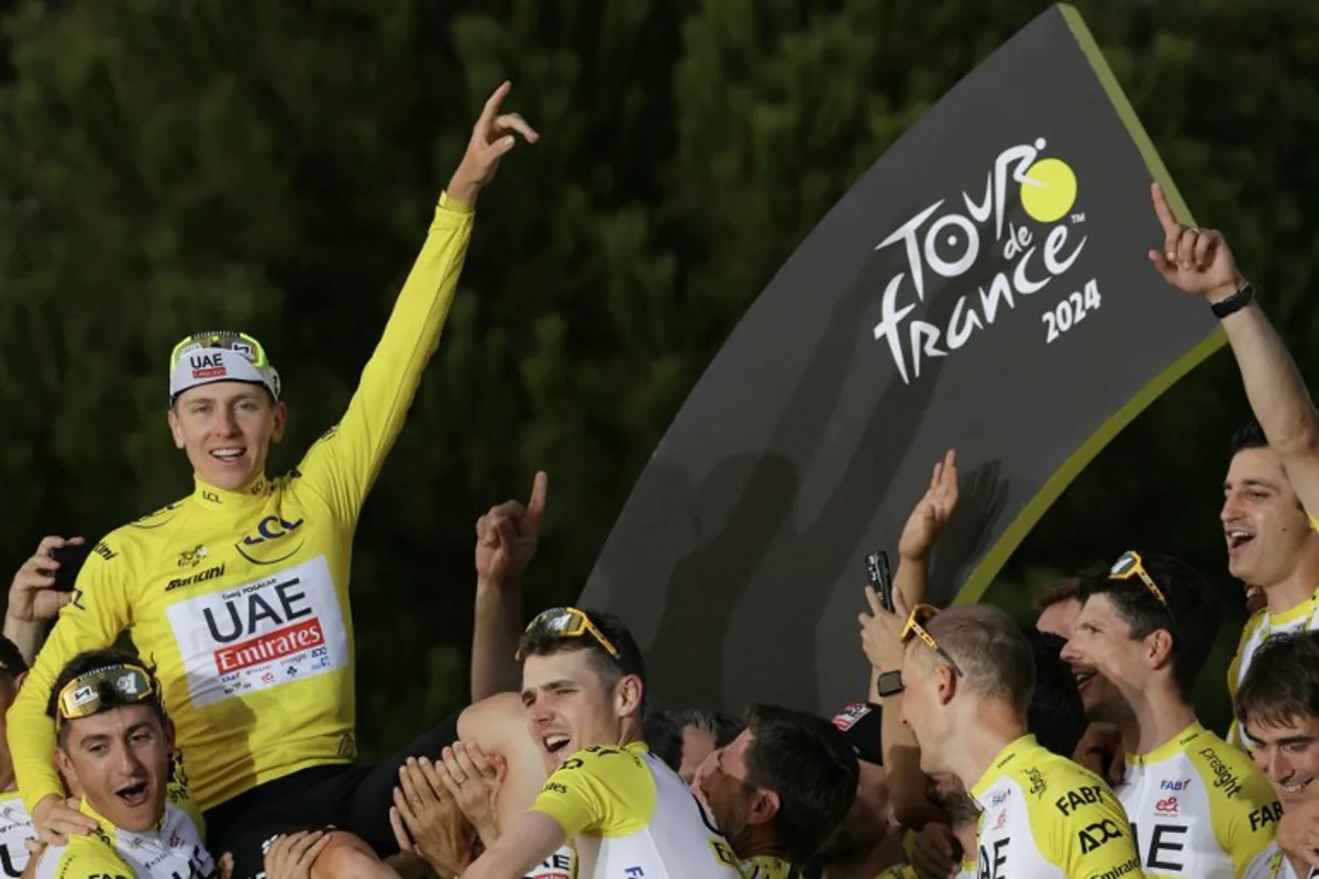 UAE Team Emirates team's Slovenian rider Tadej Pogacar celebrates his overall victory on the podium with teammates and staff after the 21st and final stage of the 111th edition of the Tour de France cycling race, a 33,7 km individual time-trial between Monaco and Nice, on July 21, 2024.  Thomas SAMSON / AFP