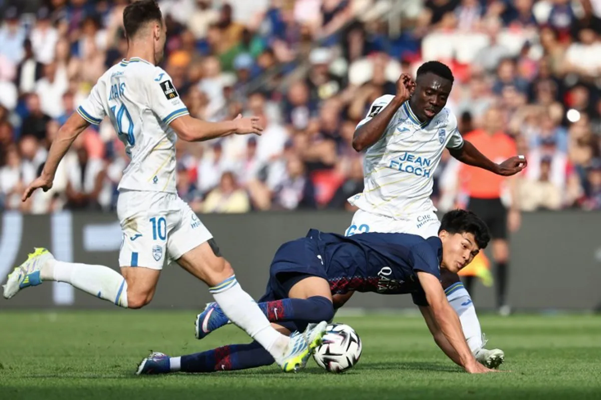 Paris Saint-Germain's Spanish midfielder #27 Dro Fernandez (C) fights for the ball with Lorient's French midfielder #10 Pablo Pagis (L) and Cameroonian midfielder #62 Arthur Avom (R) during the French L1 football match between Paris Saint-Germain (PSG) and FC Lorient at Parc des Princes stadium in Paris on May 2, 2026.  FRANCK FIFE / AFP