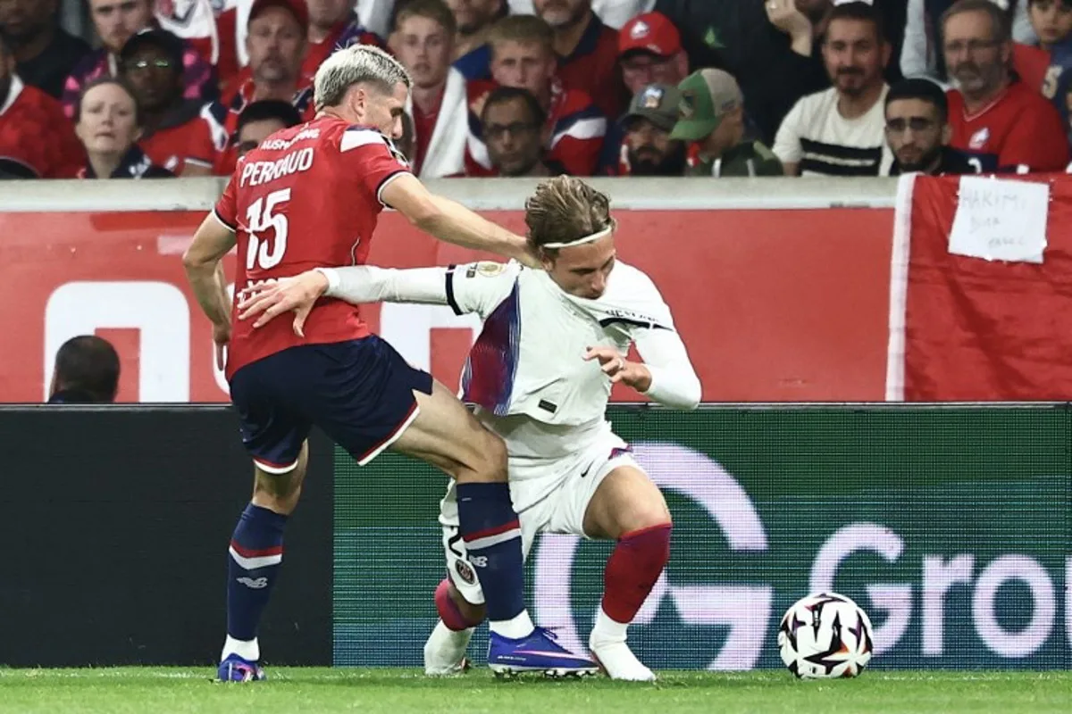 PSG's Belgian forward #22 Mika Godts (R) and Lille's French defender #15 Romain Perraud fight for the ball during the French L1 football match between Lille LOSC and Paris Saint-Germain (PSG) at the Stade Pierre-Mauroy in Villeneuve-d'Ascq, northern France, on August 28, 2026. Sameer AL-DOUMY / AFP