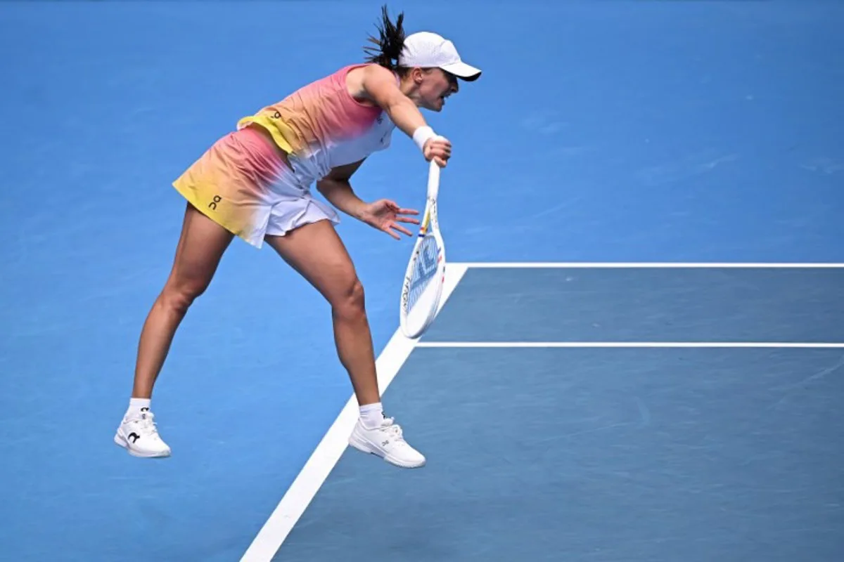 Poland's Iga Swiatek serves against Czech Republic's Katerina Siniakova during their women's singles match on day two of the Australian Open tennis tournament in Melbourne on January 13, 2025.  WILLIAM WEST / AFP