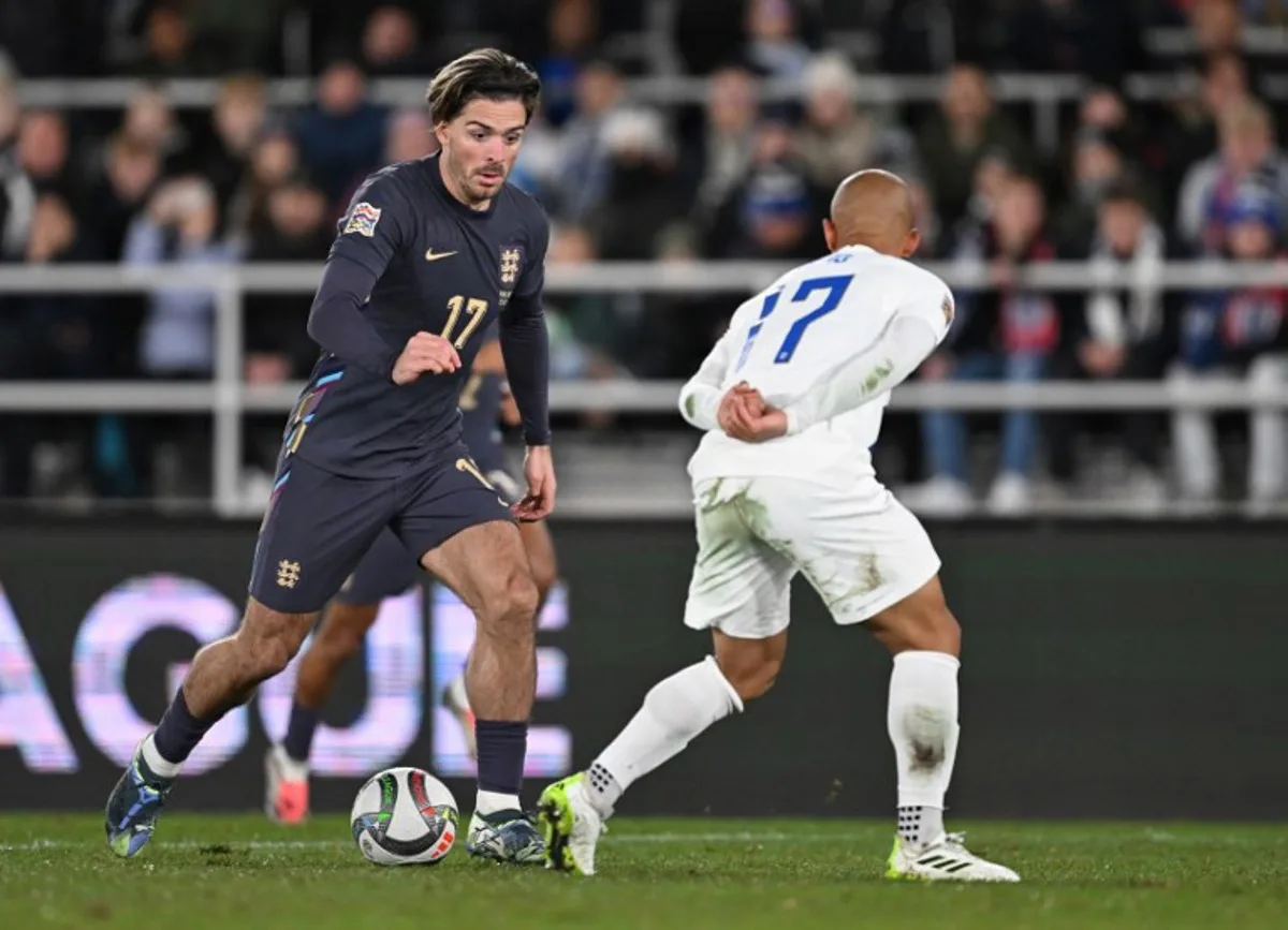 England's midfielder #17 Jack Grealish (L) and Finland's defender #17 Nikolai Alho vie for the ball during the UEFA Nations League, League B Group B2 football match Finland vs England at the Olympic Stadium in Helsinki, Finland, on October 13, 2024.  Jonathan NACKSTRAND / AFP