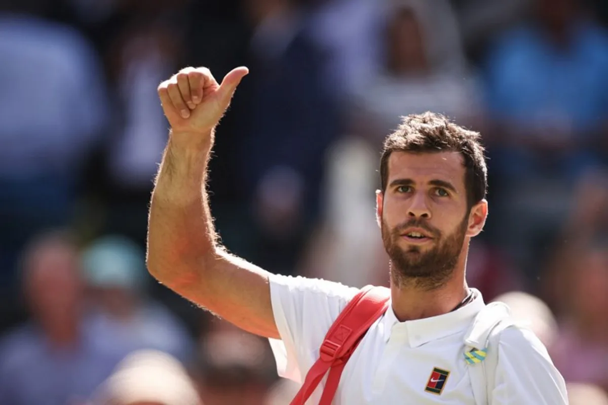 Russia's Karen Khachanov waves to the crowd as he leaves the court after losing against US player Taylor Fritz at the end of their men's singles quarter-final tennis match on the ninth day of the 2025 Wimbledon Championships at The All England Lawn Tennis and Croquet Club in Wimbledon, southwest London, on July 8, 2025.  HENRY NICHOLLS / AFP