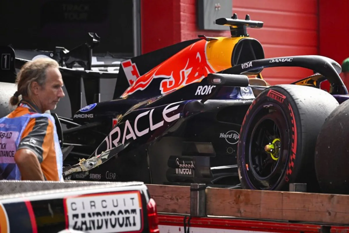 An employee stands next to the crashed car of Red Bull Racing's Dutch driver Max Verstappen during the Formula One Dutch Grand Prix at The Circuit Zandvoort, western Netherlands, on August 23, 2026.  JOHN THYS / AFP