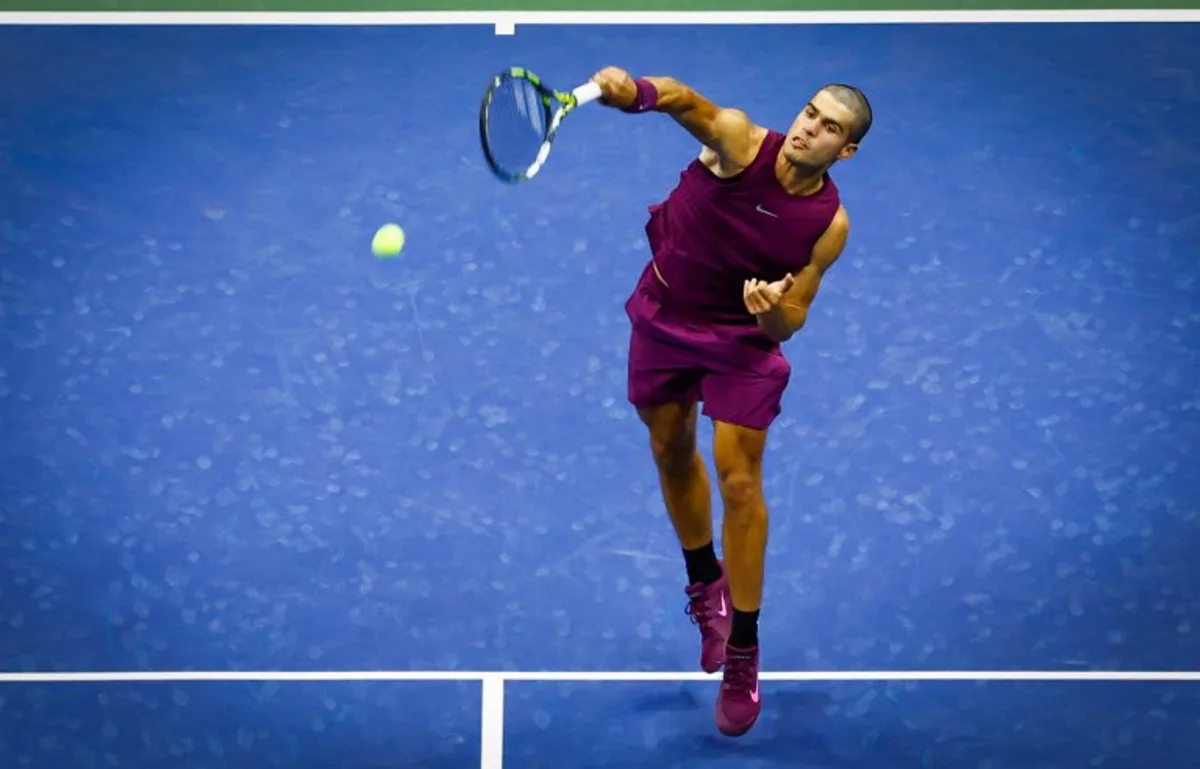 Spain's Carlos Alcaraz serves to USA's Reilly Opelka during their men's singles first round tennis match on day two of the US Open tennis tournament at the USTA Billie Jean King National Tennis Center in New York City, on August 25, 2025. Kena Betancur / AFP