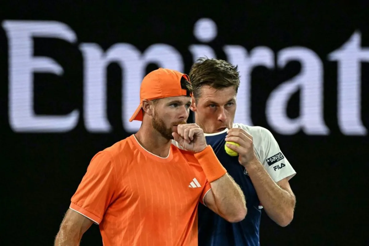 Great Britain's Neal Skupski (R) speaks with partner USA's Christian Harrison during their men's doubles final match against Australia's Jason Kubler and Marc Polmans on day fourteen of the Australian Open tennis tournament in Melbourne on January 31, 2026.  WILLIAM WEST / AFP
