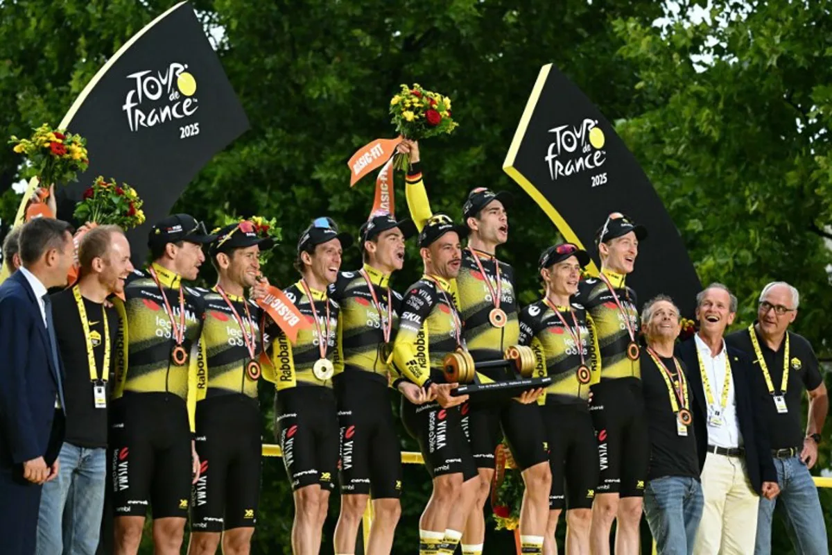 Team Visma - Lease a Bike riders celebrate on the podium with the best team award after the 21st and final stage of the 112th edition of the Tour de France cycling race, 132.3 km between Mantes-la-Ville and Paris Champs-Élysees, on July 27, 2025. Loic VENANCE / AFP