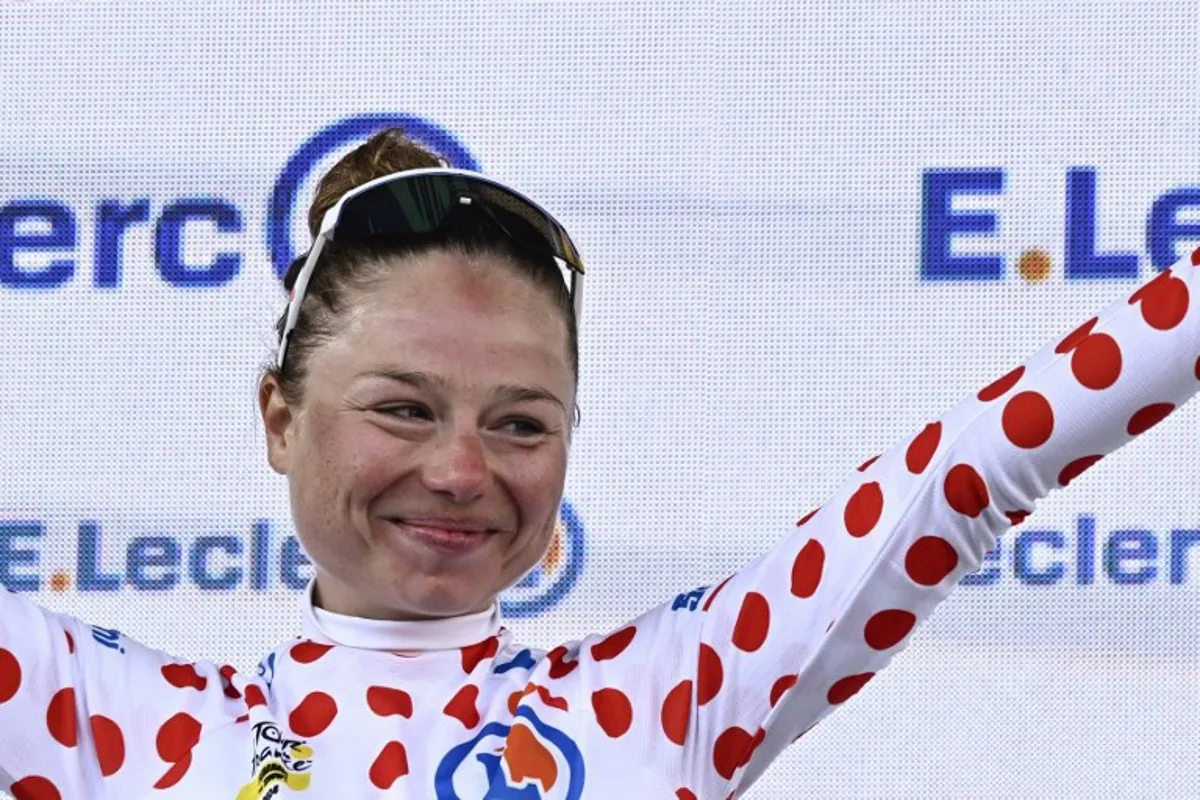 AG Insurance - Soudal Team's Belgian rider Justine Ghekiere celebrates on the podium wearing the climber's polka dot (dotted) jersey after competing in the 8th and last stage of the third edition of the Women's Tour de France cycling race, a 149.9 km between Le Grand Bornand and the Alpe d'Huez, in L'Alpes d'Huez, south-eastern France, on August 18, 2024.  JULIEN DE ROSA / AFP