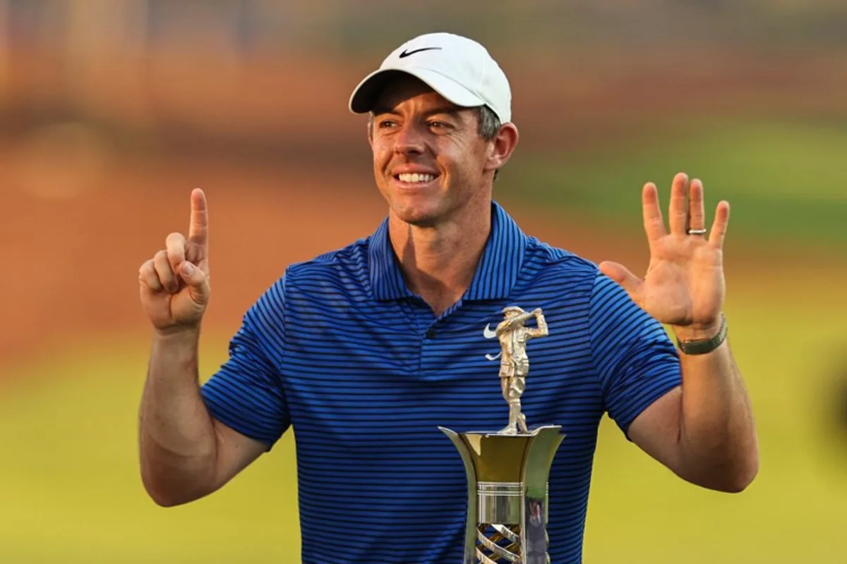 Northern Ireland's Rory McIlroy gestures as he poses for a picture with the trophy after winning the DP World Tour Championship golf tournament at Jumeirah Golf Estates in Dubai on November 17, 2024.  FADEL SENNA / AFP