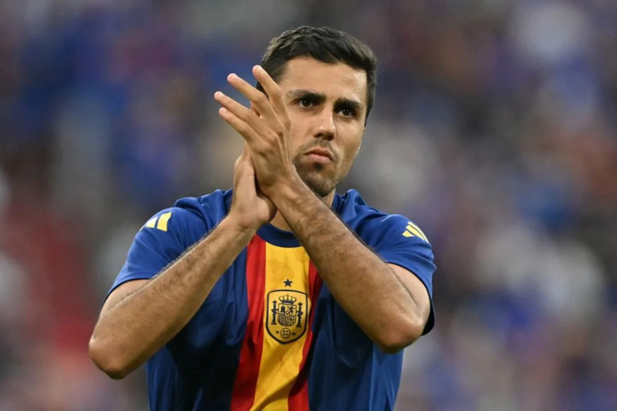 Spain's midfielder #16 Rodri greets fans during warm ups ahead of the UEFA Euro 2024 semi-final football match between Spain and France at the Munich Football Arena in Munich on July 9, 2024. MIGUEL MEDINA / AFP