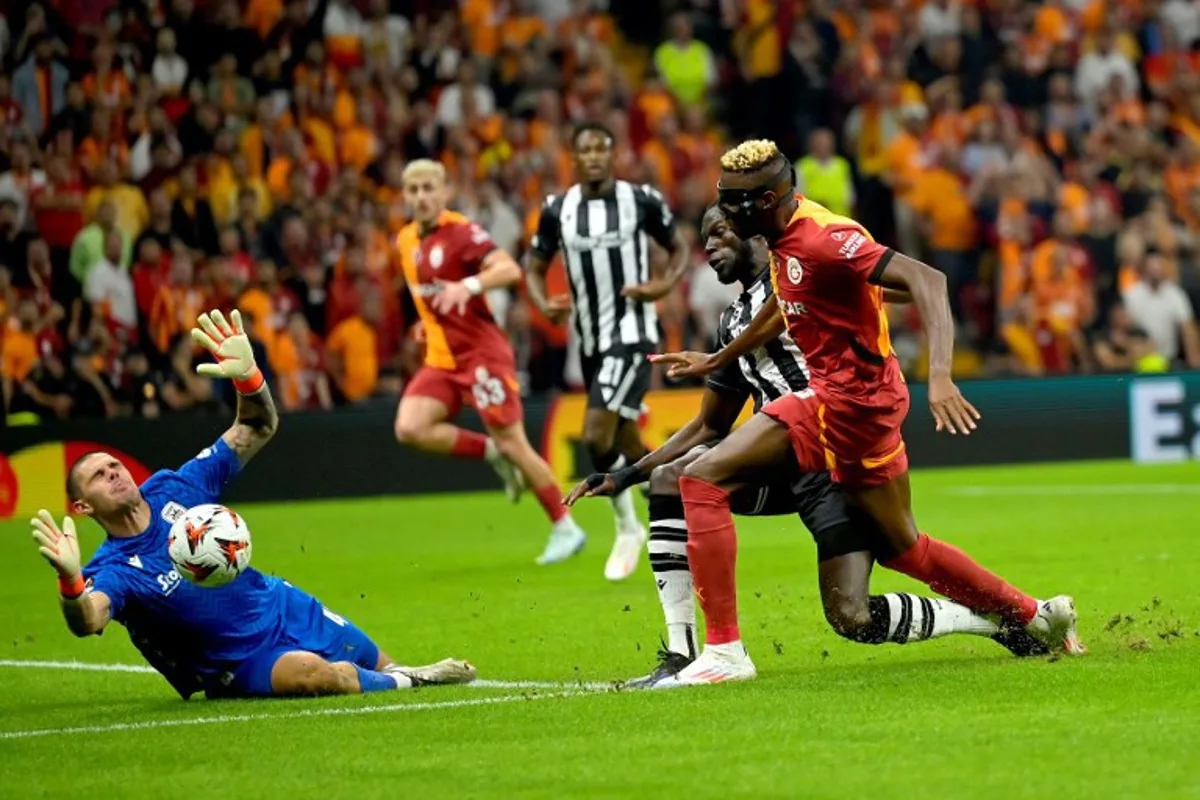 Paok's Croatian goalkeeper #42 (L) makes a save as Galatasaray's Nigerian forward #45 Victor Osimhen (R) reacts during the UEFA Europa League 1st round day 1 football match between Galatasaray SK and PAOK FC at the Ali Sami Yen Sports Complex in Sisli, near Istanbul, on September 25, 2024.  Yasin AKGUL / AFP