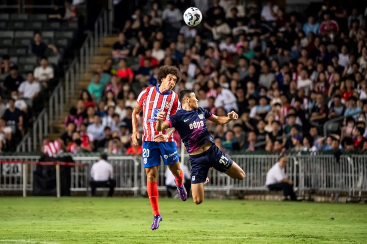 Atletico Madrid's Axel Witsel (L) and Kitchee's Sherzod Temirov compete for the ball during a friendly football match between Hong Kong's Kitchee and Spain's Atletico Madrid at the Hong Kong stadium in Hong Kong on August 7, 2024.  Isaac LAWRENCE / AFP