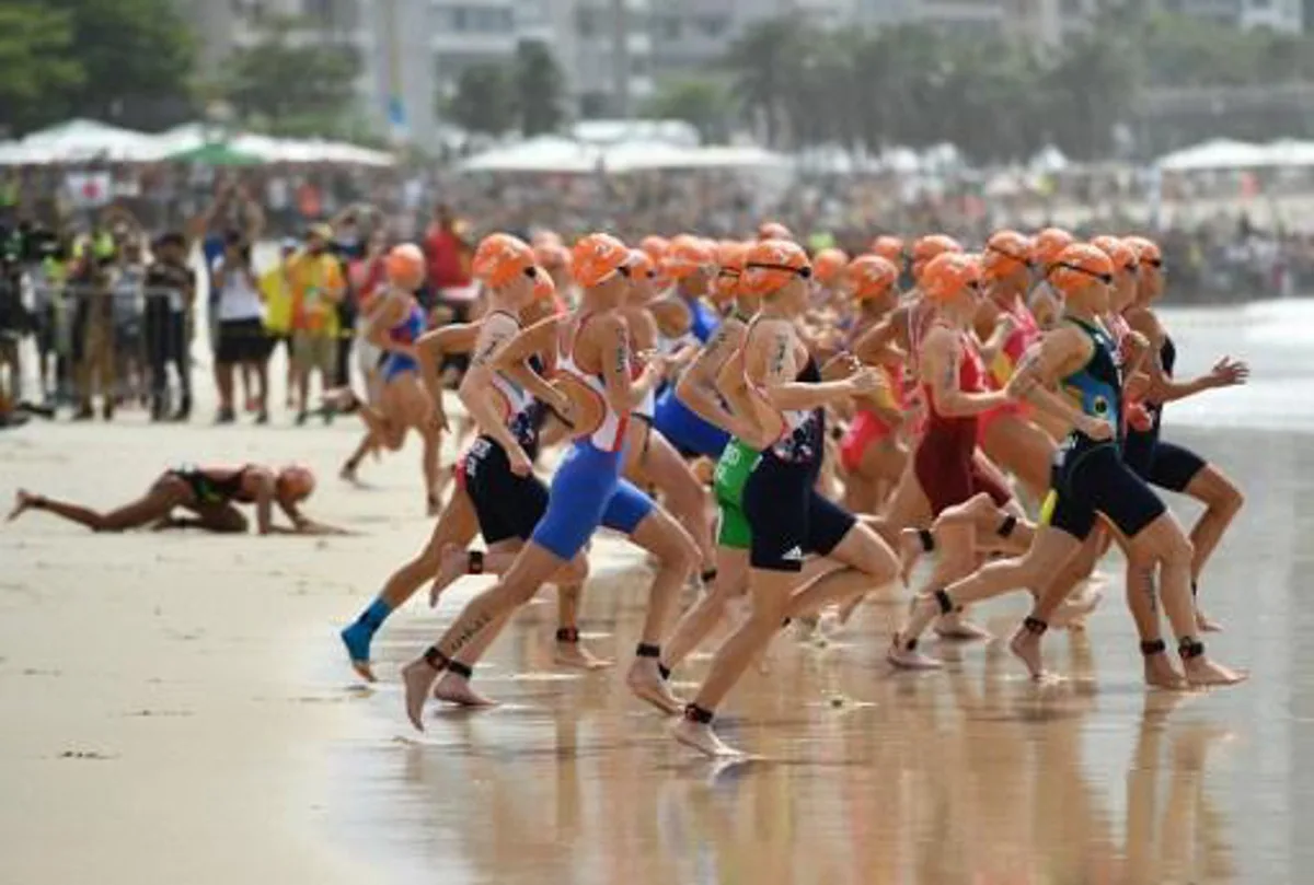 Athletes run into the water for the swimming portion of the women's triathlon, as one competitor (L) falls behind them, at Fort Copacabana during the Rio 2016 Olympic Games in Rio de Janeiro on August 20, 2016. 
Leon NEAL / AFP