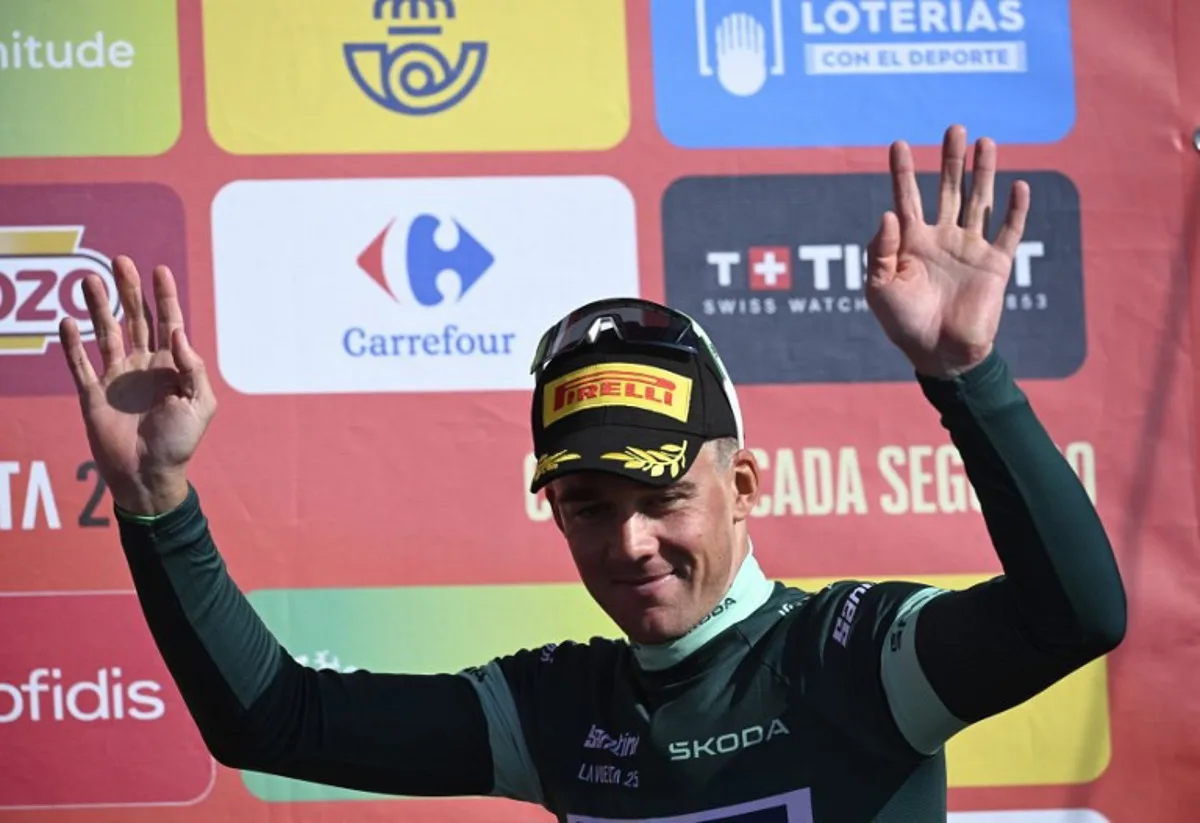 Team Lidl-Trek's Danish rider Mads Pedersen wearing the points ranking leader's green jersey celebrates on the podium after the 13th stage of the Vuelta a Espana, a 202 km race between Cabezon de la Sal and L'Angliru, on September 5, 2025. Miguel RIOPA / AFP