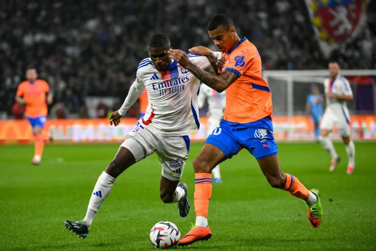 Lyon's Angolan defender #22 Clinton Mata (L) fights for the ball with Marseille's English forward #10 Mason Greenwood during the French L1 football match between Olympique Lyonnais (OL) and Olympique de Marseille at The Groupama Stadium in Decines-Charpieu, central-eastern France, on September 22, 2024.  JEFF PACHOUD / AFP