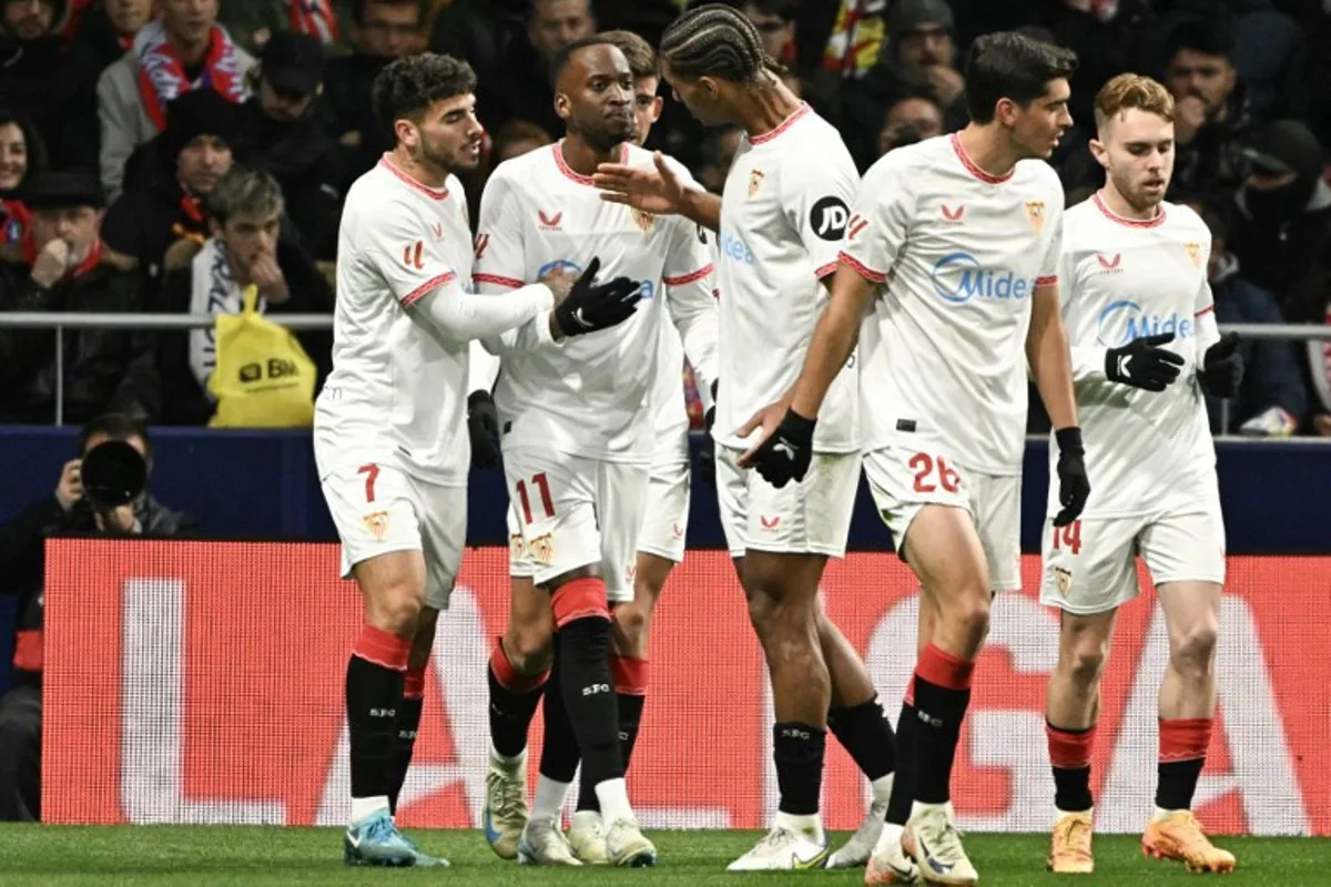 Sevilla's Belgian forward #11 Dodi Lukebakio (2L) celebrates after scoring their first goal during the Spanish league football match between Club Atletico de Madrid and Sevilla FC at the Metropolitano stadium in Madrid on December 8, 2024.  JAVIER SORIANO / AFP