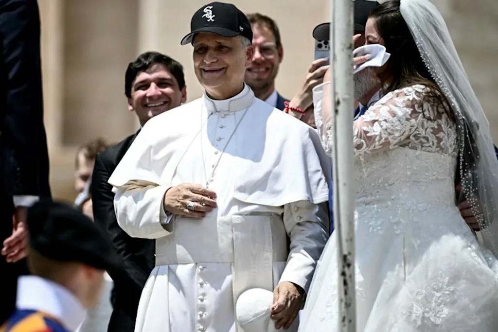 Pope Leo XIV (C) reacts wearing a Chicago White Sox baseball team cap as he meets newly wedded couples during the weekly general audience in St Peter's Square at the Vatican on June 11, 2025.  Filippo MONTEFORTE / AFP