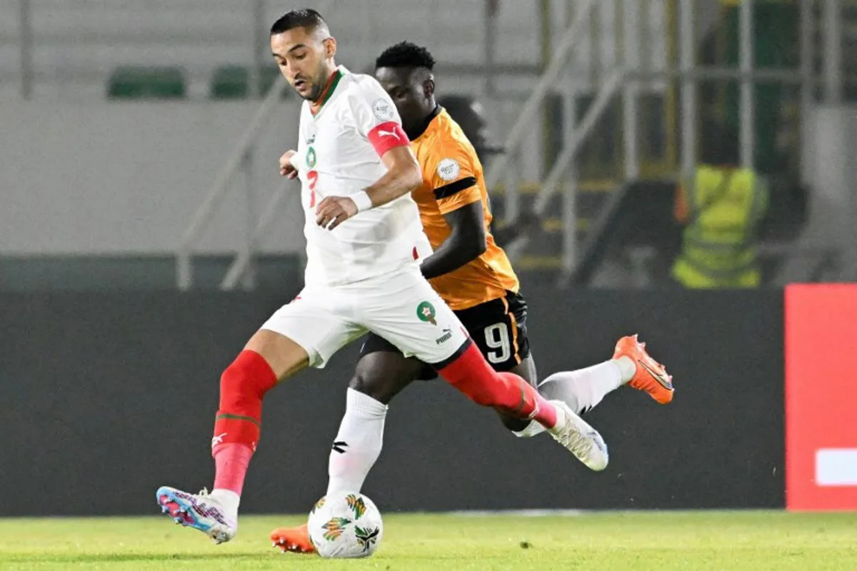 Morocco's midfielder #7 Hakim Ziyech (L) fights for the ball with with Zambia's forward #9 Lameck Banda during the Africa Cup of Nations (CAN) 2024 group F football match between Zambia and Morocco at the Stade Laurent Pokou in San Pedro on January 24, 2024.  SIA KAMBOU / AFP