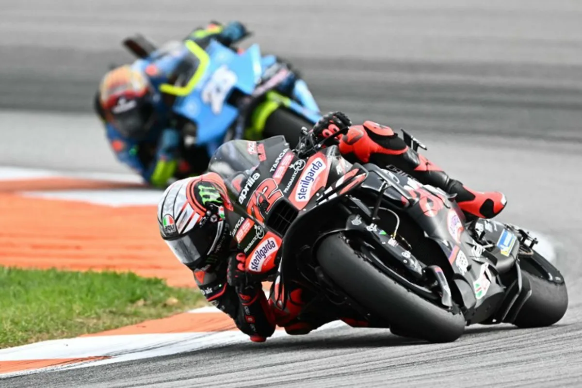 Aprilia Racing team's Italian MotoGP rider Marco Bezzecchi rides ahead of Trackhouse MotoGP Team's Spanish rider Raul Fernandez during the MotoGP race of the Valencia Grand Prix at the Ricardo Tormo racetrack in Cheste on November 16, 2025. JOSE JORDAN / AFP