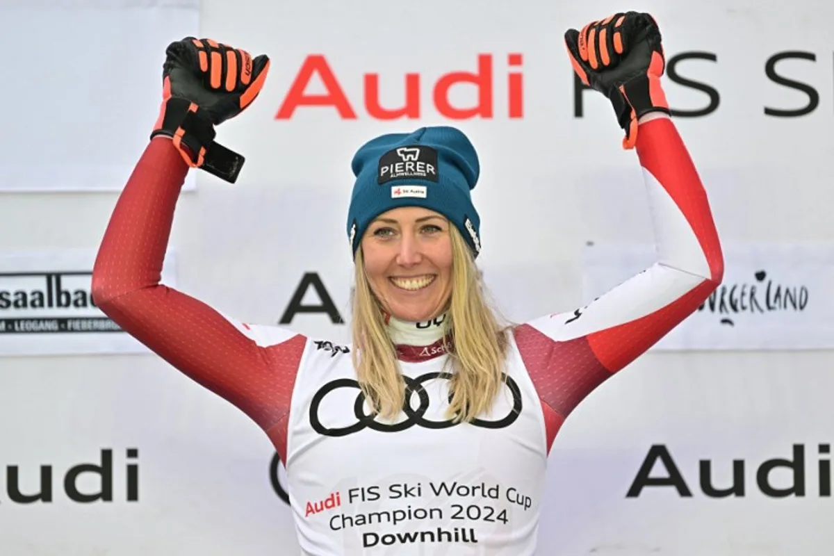 Season's overall winner of the Downhill competition Austria's Cornelia Hutter celebrates on the podium after the downhill event of the FIS Alpine Skiing Women's World Cup in Saalbach, Austria on March 23, 2024.   Joe Klamar / AFP