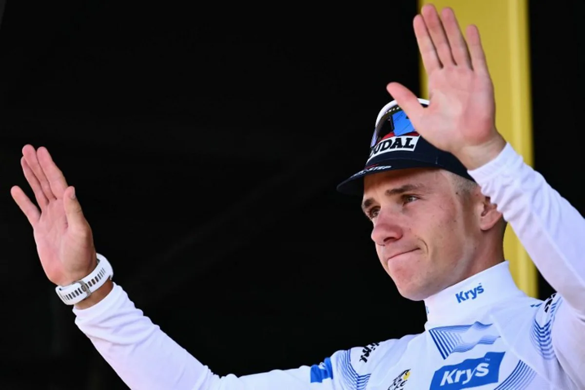 Soudal Quick-Step team's Belgian rider Remco Evenepoel celebrates on the podium with the best young rider's white jersey after the 13th stage of the 112th edition of the Tour de France cycling race, 10.9 km individual time trial between Loudenvielle and Peyragudes, in the Pyrenees mountains of southwestern France, on July 18, 2025. Marco BERTORELLO / AFP