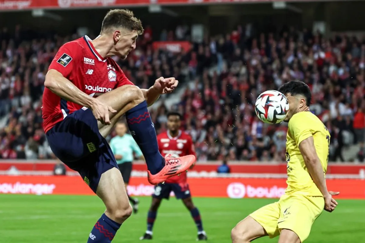 Lille's Belgian defender #12 Thomas Meunier (L) kicks the ball and hits the face of Toulouse's Chilean defender #17 Gabriel Suazo during the French L1 football match between Lille LOSC and Toulouse FC at Stade Pierre-Mauroy in Villeneuve-d'Ascq, northern France on October 5, 2024.  Sameer Al-DOUMY / AFP