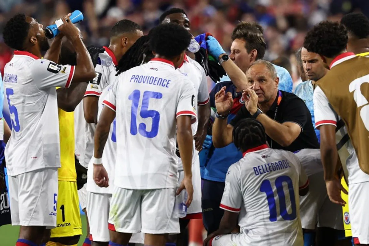 Haiti's French head coach Sebastien Migne talks to his players during the hydration break during the 2026 World Cup Group C football match between Haiti and Scotland at the Boston Stadium in Foxborough on June 13, 2026. FRANCK FIFE / AFP