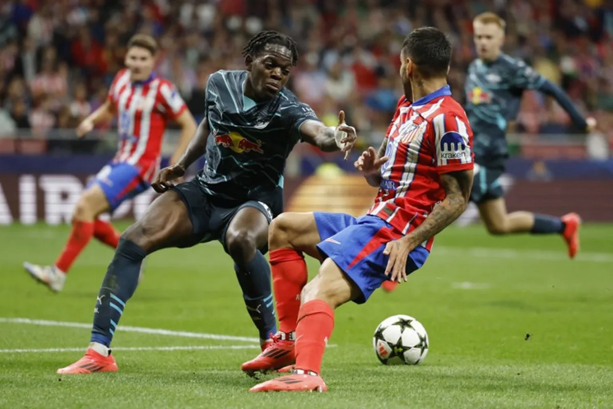 Atletico Madrid's Argentine forward #10 Angel Correa and RB Leipzig's French defender #23 Castello Lukeba (L) vie for the ball during the UEFA Champions League 1st round football match between Club Atletico de Madrid and RB Leipzig at the Metropolitano stadium in Madrid on September 19, 2024.  OSCAR DEL POZO / AFP