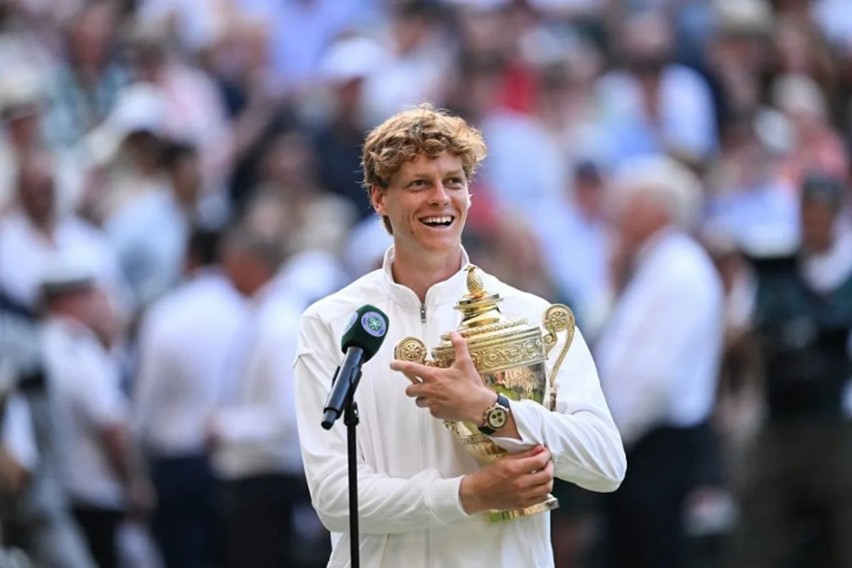 Italy's Jannik Sinner speaks to the audience with his trophy following his victory against Spain's Carlos Alcaraz at the end of their men's singles final tennis match on the fourteenth day of the 2025 Wimbledon Championships at The All England Lawn Tennis and Croquet Club in Wimbledon, southwest London, on July 13, 2025. Kirill KUDRYAVTSEV / AFP
