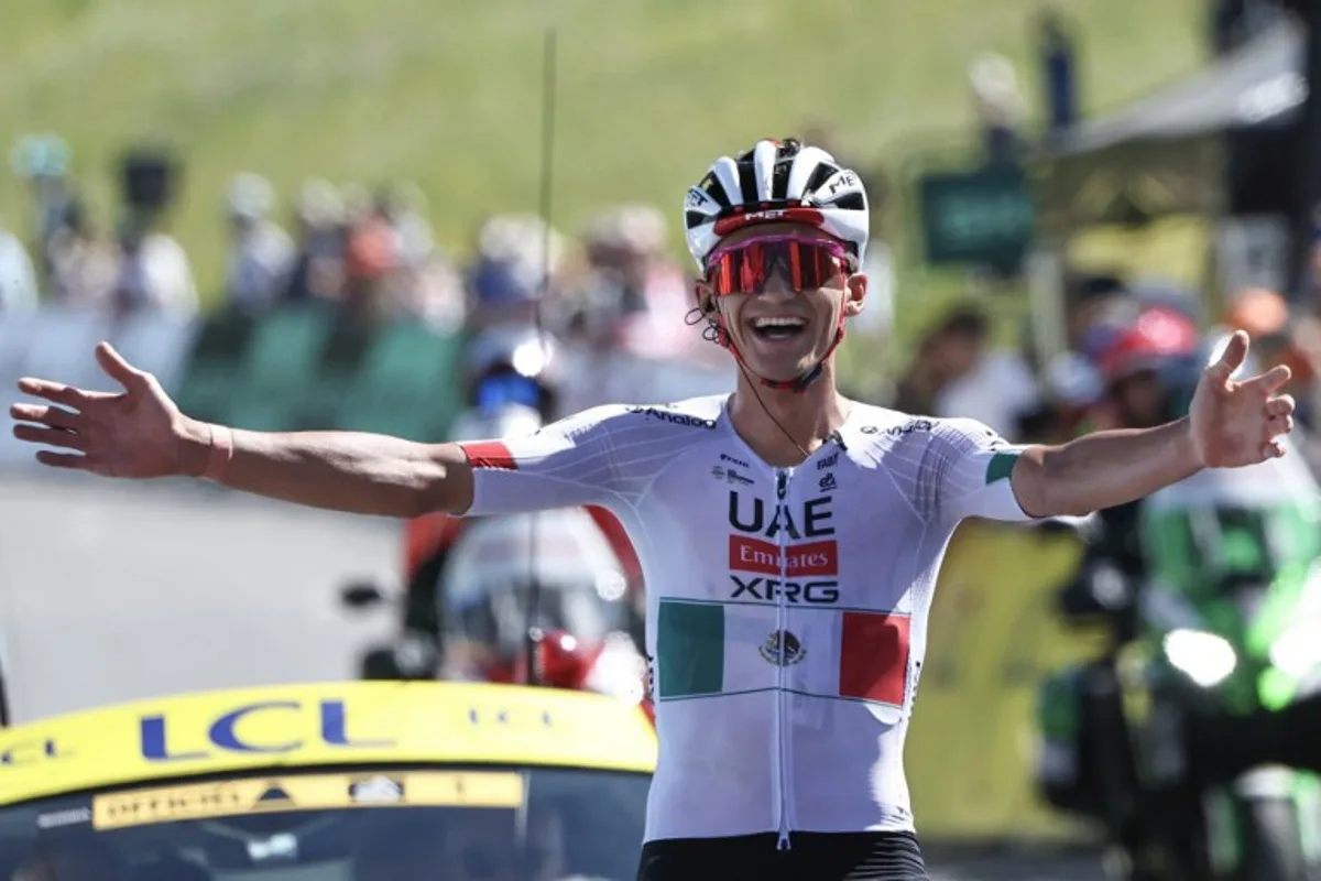 UAE Team Emirates XRG's Mexican rider Isaac Del Toro Romero celebrates as he cycles to the finish line to win the 8th and final stage of the Tour Auvergne-Rhone-Alpes cycling race (formerly known as the Criterium du Dauphine), 120,1km between Beaufort and Plateau de Solaison, in the French Alps on June 14, 2026. Anne-Christine POUJOULAT / AFP