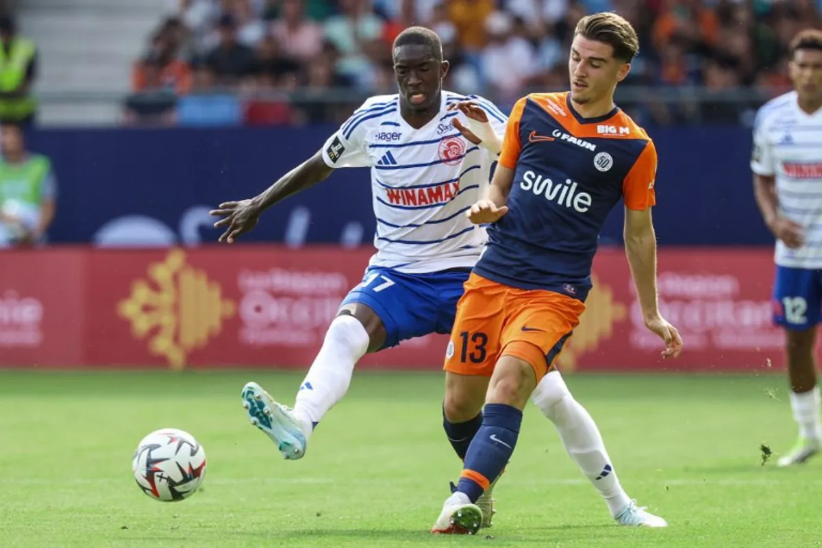 Montpellier's French midfielder #13 Joris Chotard (R) fights for the ball with Strasbourg's Senegalese midfielder #17 Pape Diong during the French L1 football match between Montpellier Herault SC and Strasbourg FC at Stade de la Mosson in Montpellier, southern France on August 18, 2024. Pascal GUYOT / AFP